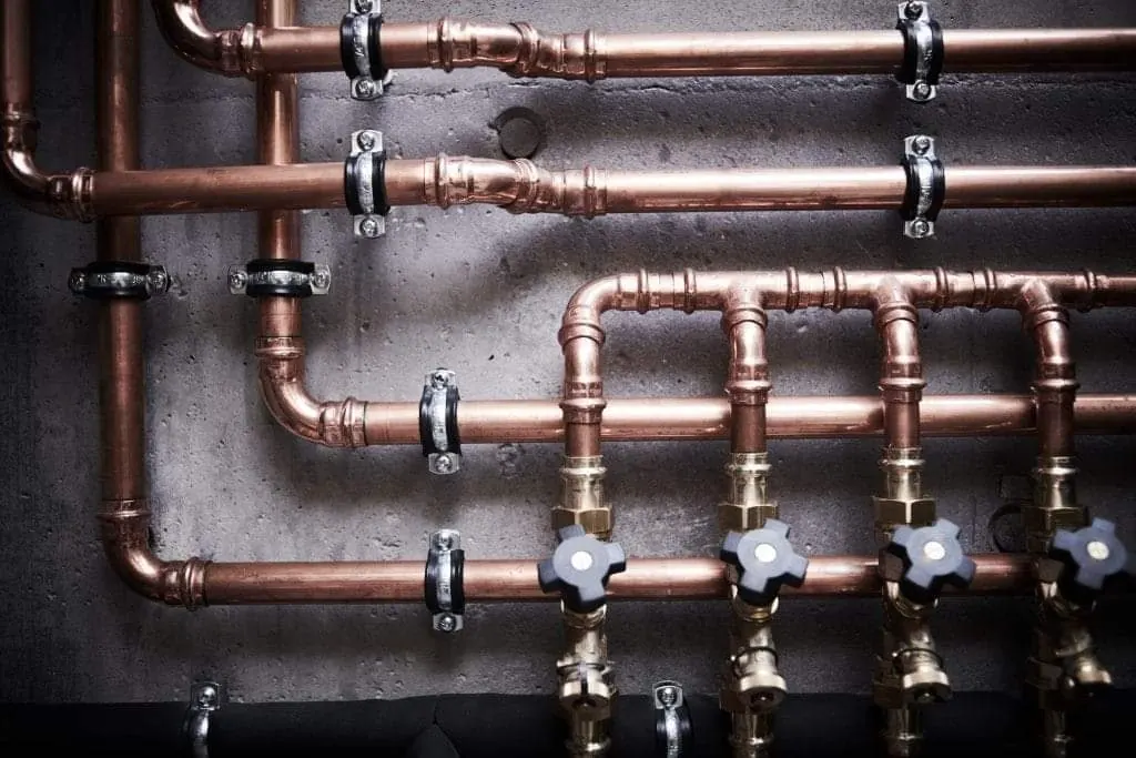Detailed copper plumbing manifold with labeled branches
